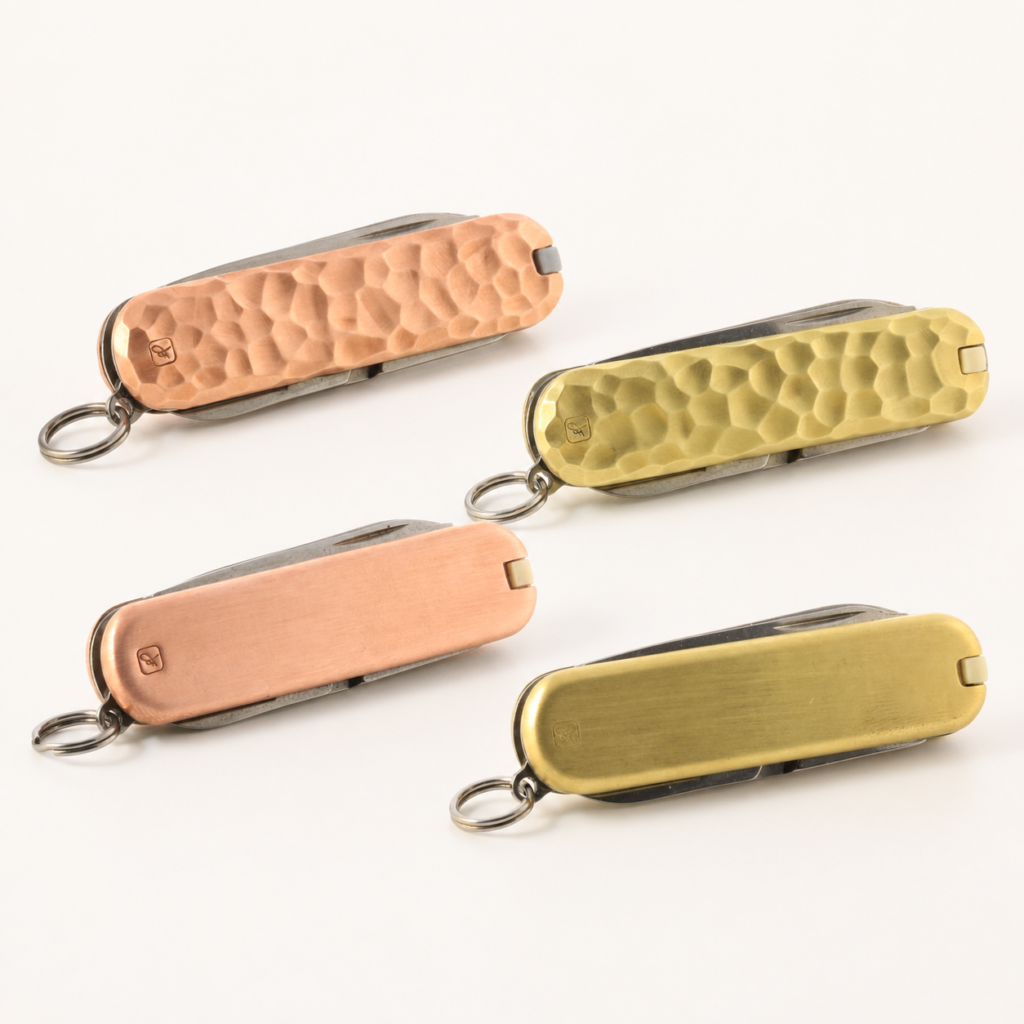 Copper and brass Victorinox Classic SD pocket knives in solid and hammered finishes
